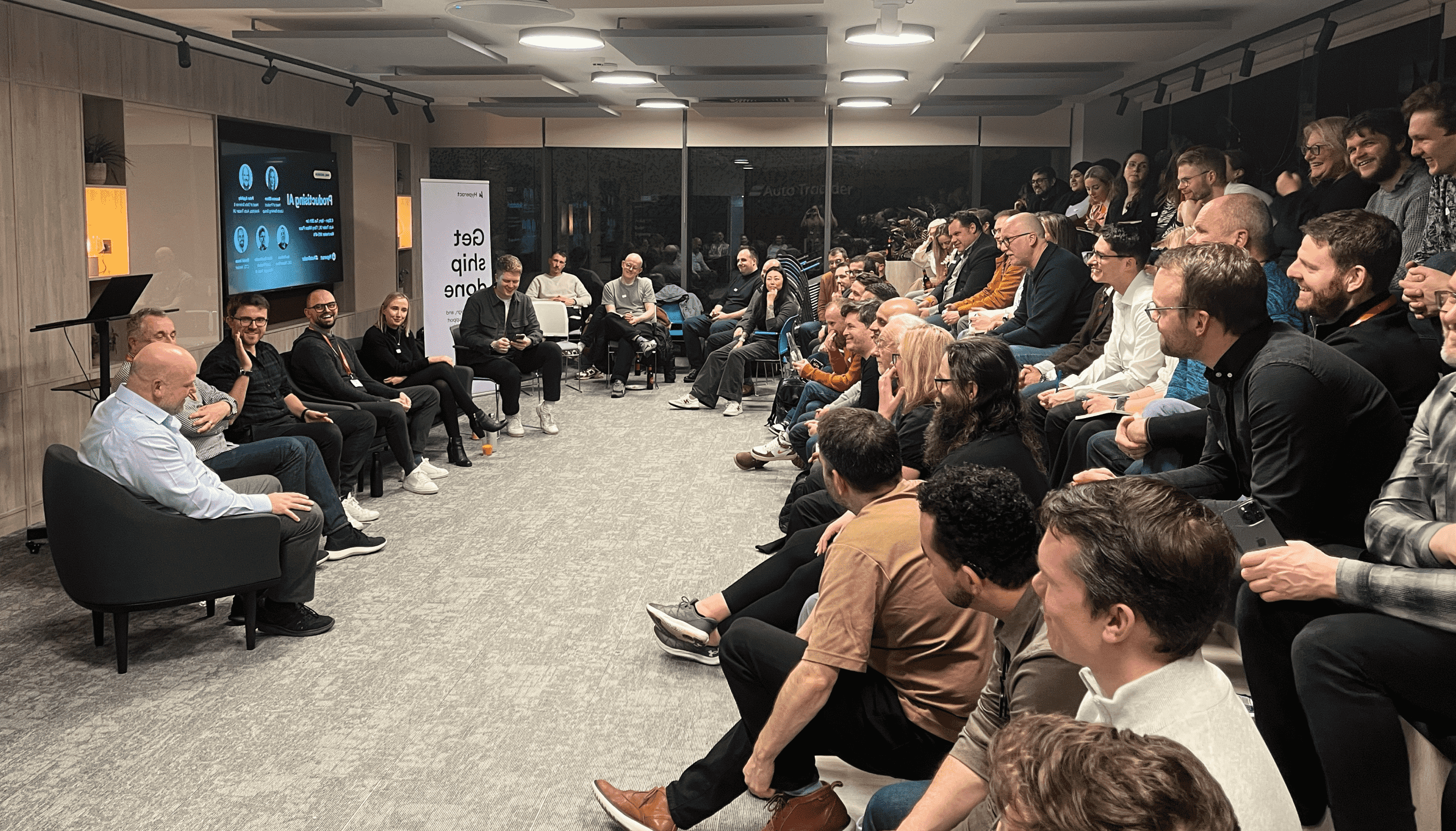 A picture showing a panel discussion in a busy room